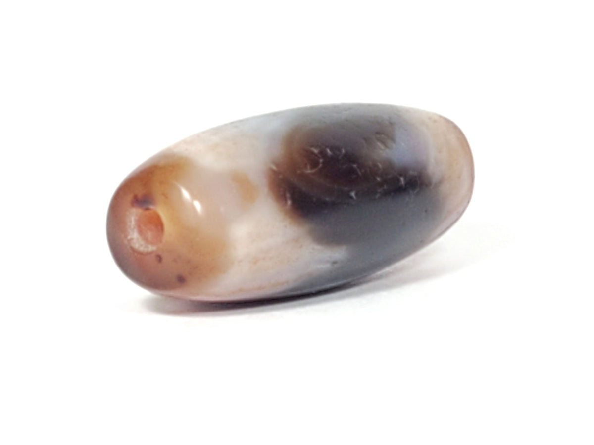 Macro view of Tasso dzi bead showing layered orange-red and white agate banding with bloodspot detail, At-052526-TaBS