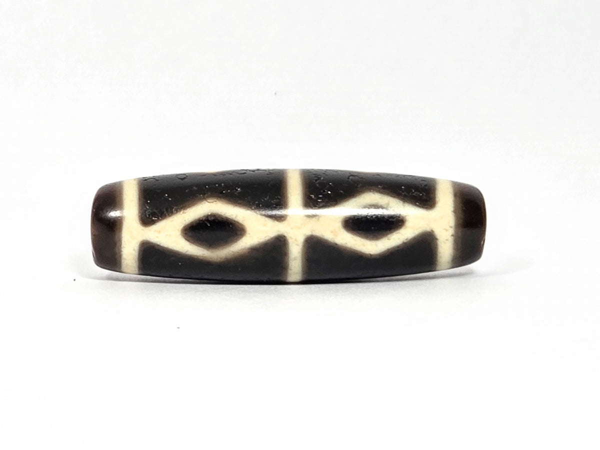 At-072226-6EDS Six Eye Diamond Spear face B — two diamond eyes, cream vertical connector, pitch-black ground, unretouched.