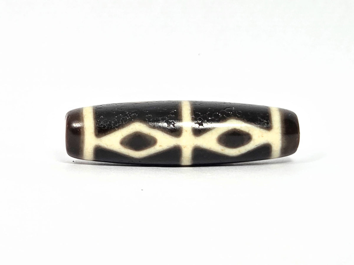At-072226-6EDS Six Eye Diamond Spear face C low angle — cream spear arcs, dark body, warm brown end cap visible, unretouched.