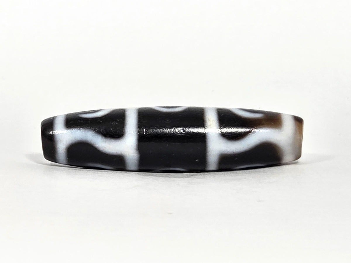 At-071426-GRS Guru Rinpoche Scepter face B low angle — arch-wave pattern, warm brown end cap, unretouched.