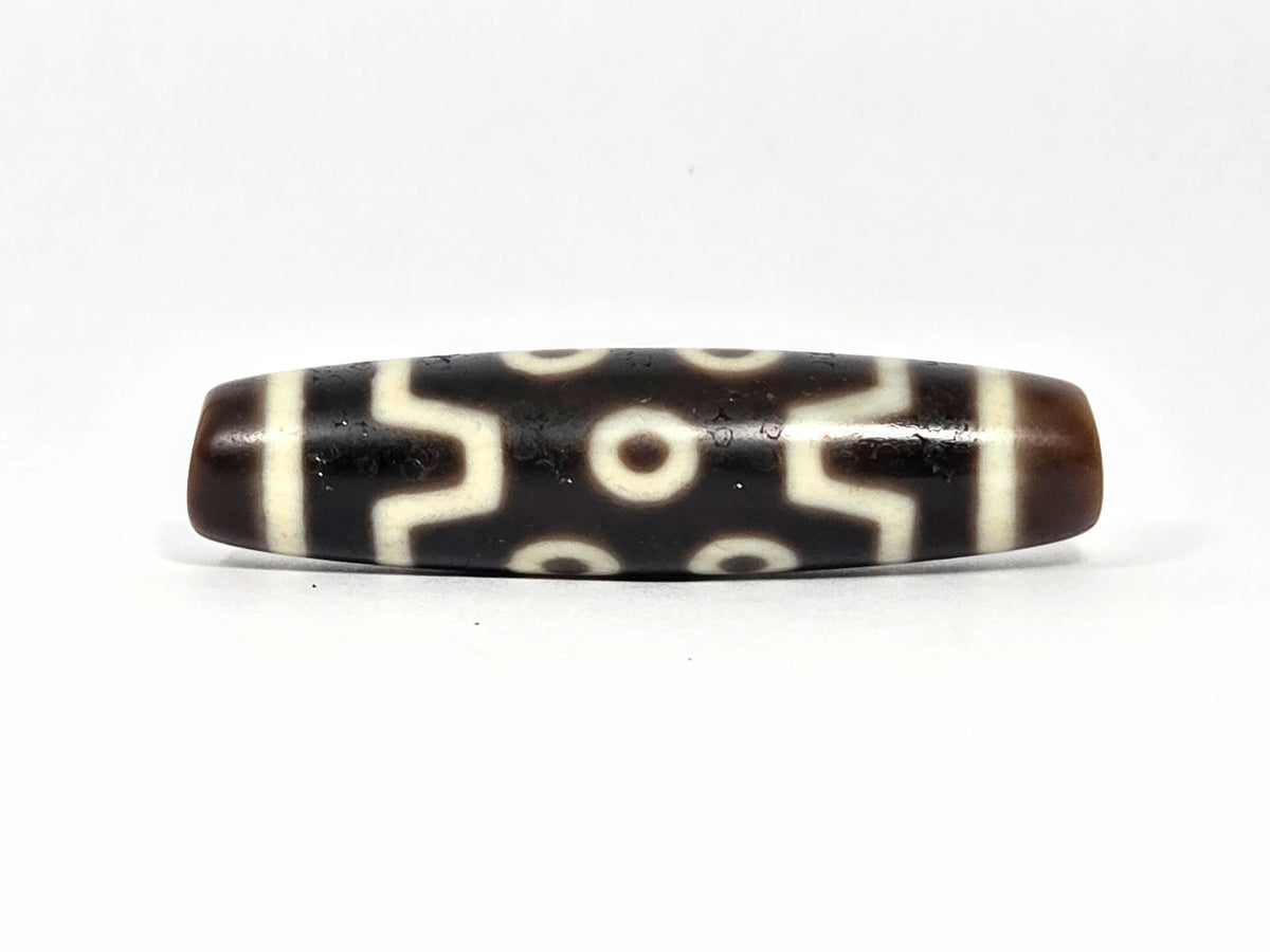 Seven Eye At-072226-7E 50.7×12.7mm pitch-black agate face A — S-curve connectors, eye distribution, unretouched.