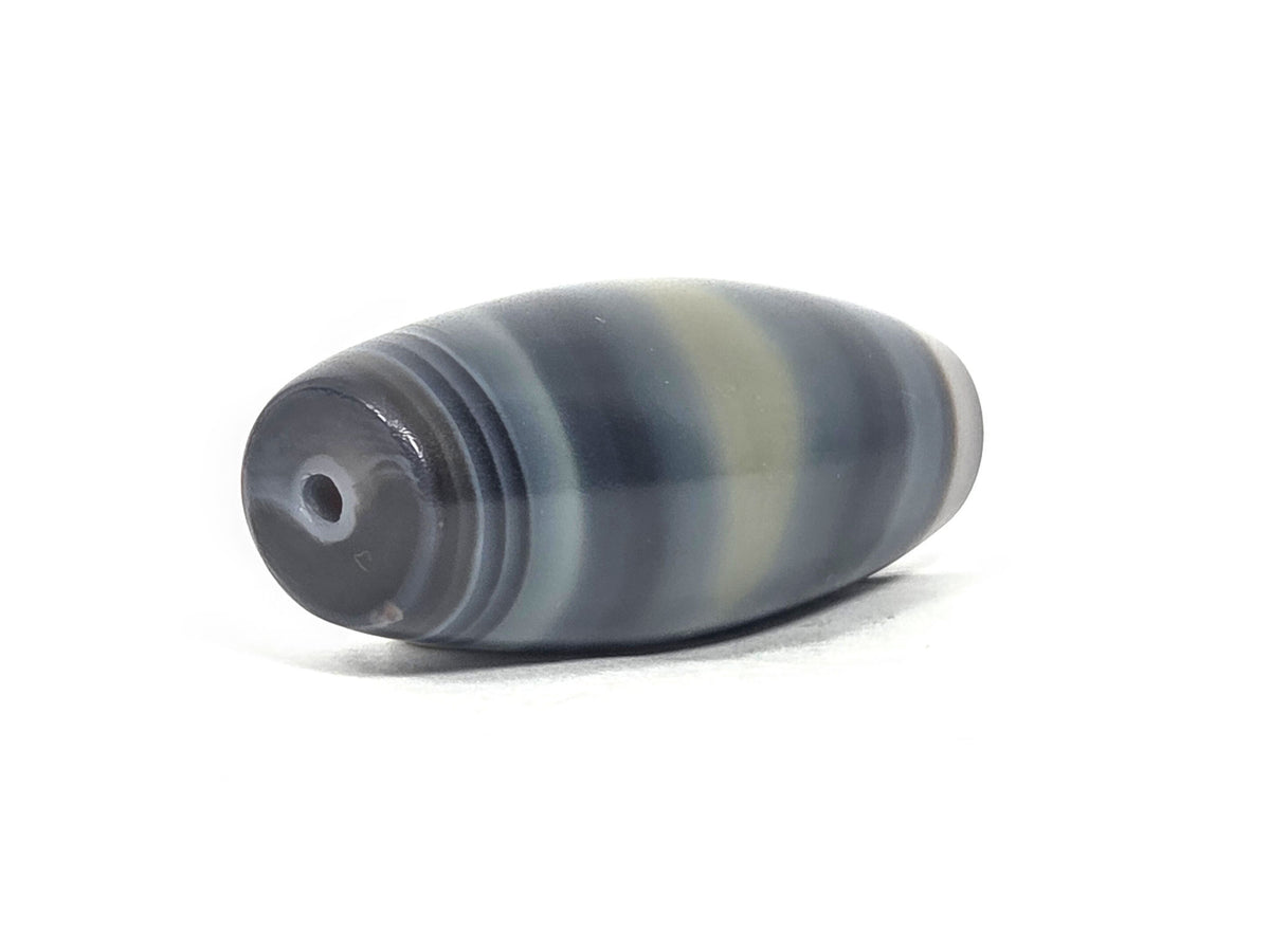 N-N-071426-1E4 end angle A — warm grey-brown end cap, small clean drill opening, banding wrap visible, unretouched.