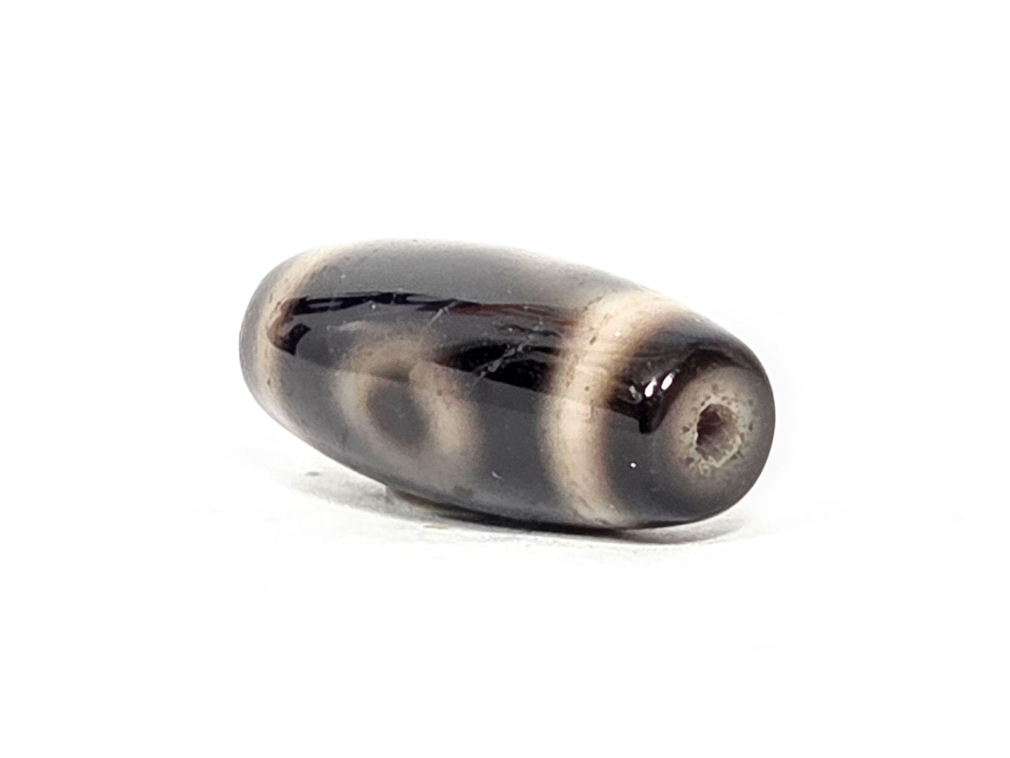 Two Eye motif N-FA-071426-2E drill end angle A — dark end cap, clean drill opening, 28.3×11.3mm, unretouched.