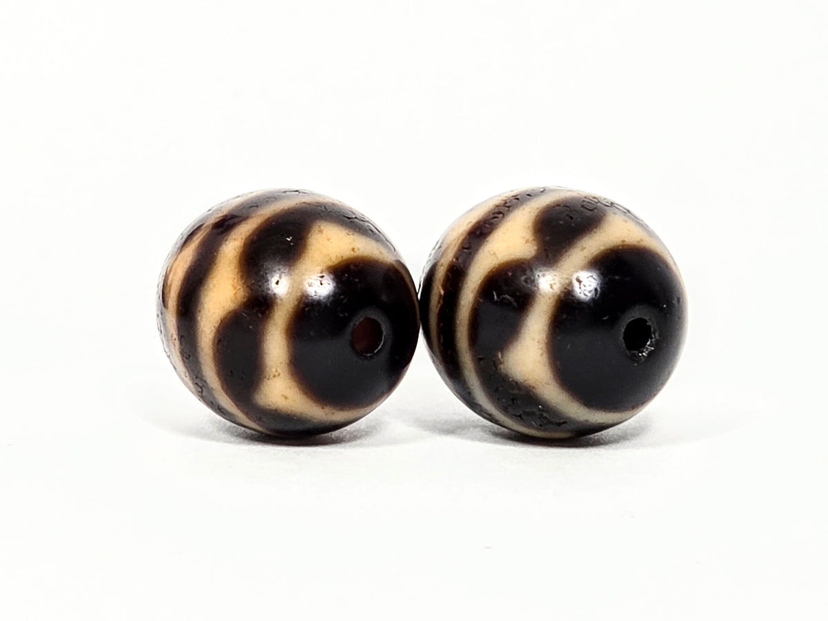V-060426-DWP drill hole face A, honey-tan wave bands wrapping to centre hole, dark brown ground, unretouched