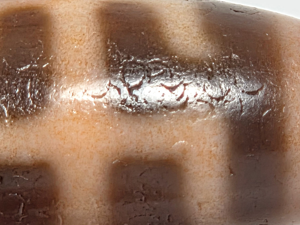 V-071426-BNF macro 1 — reddish-brown cinnabar inclusions at cream zone boundaries, Tier 2 bloodspots, unretouched.