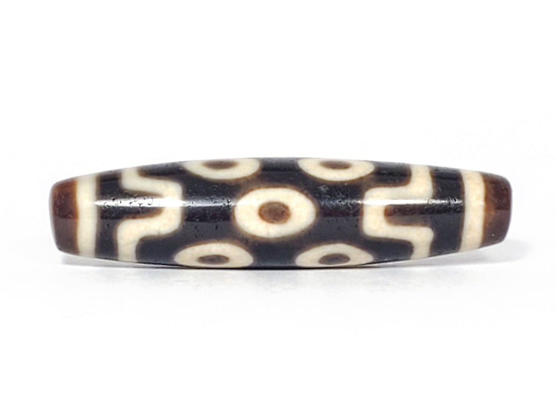 Ancient Tibetan seven-eye dzi bead, dark ground, two rows of cream eyes with wave dividers, unretouched