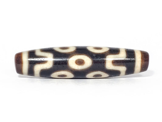 Ancient Tibetan seven-eye dzi bead, dark ground, two rows of cream eyes with wave dividers, unretouched