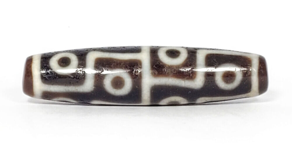 Authentic antique twelve eye dzi bead — rich dark brown agate with crisp white etched eye motifs, natural surface aging visible, from Ancient Dzi Shop
