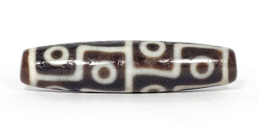 Authentic antique twelve eye dzi bead — rich dark brown agate with crisp white etched eye motifs, natural surface aging visible, from Ancient Dzi Shop