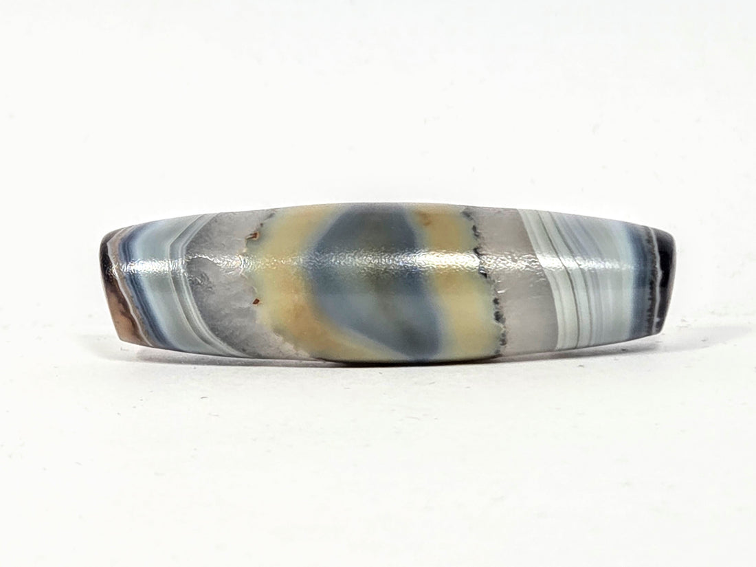 Antique natural dzi bead with unretouched naturally formed eye pattern in grey cream and slate blue banding — no etching or artificial treatment