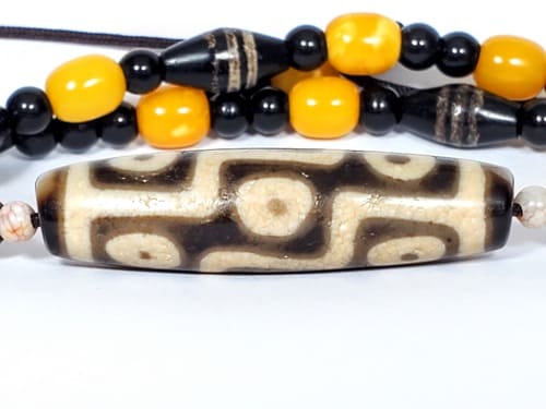 Authentic ancient Tibetan nine eye dzi bead showing natural agate patina and genuine weathering marks