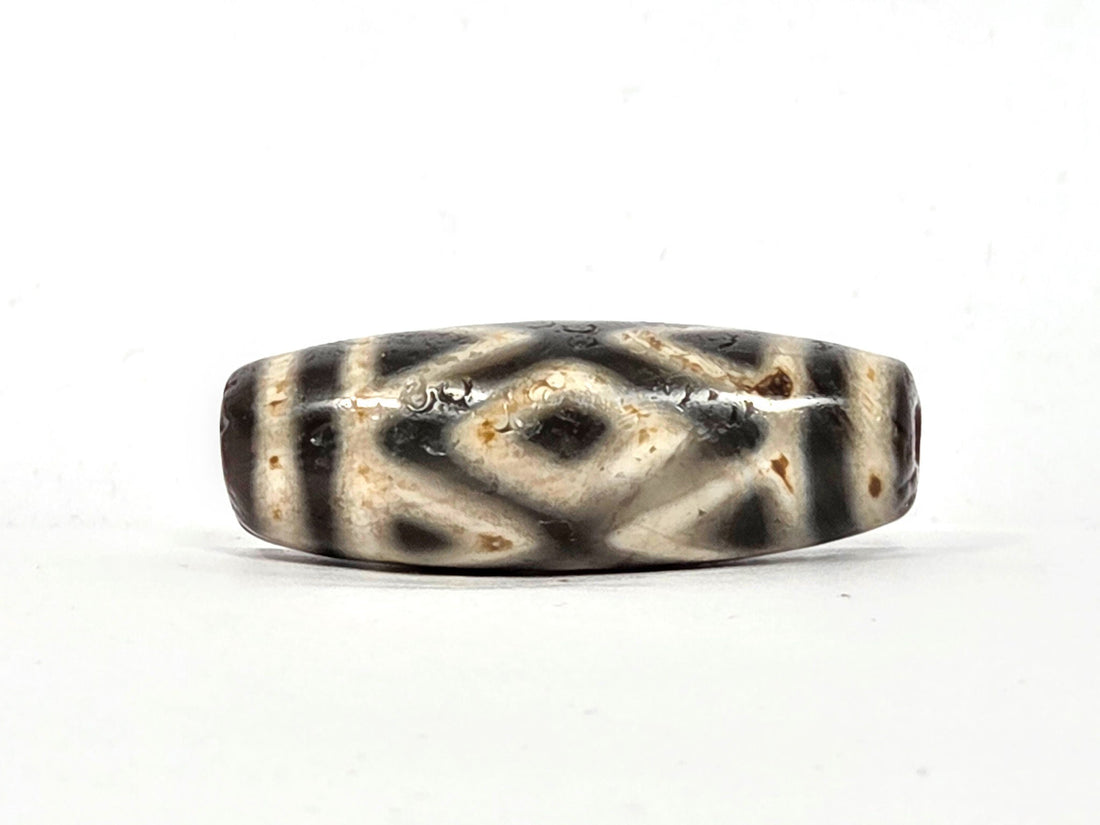 Ancient Tibetan dzi bead, three diamond eye and tiger tooth motif, pale cream and dark charcoal agate, cinnabar bloodspot inclusions, natural age patina, Ancient Dzi Shop