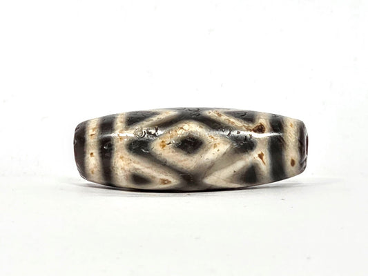 Ancient Tibetan dzi bead, three diamond eye and tiger tooth motif, pale cream and dark charcoal agate, cinnabar bloodspot inclusions, natural age patina, Ancient Dzi Shop