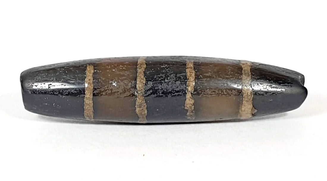 Ancient seven stripe chung dzi bead with golden-tan etched bands on near-pitch-black agate, unretouched photo by Ancient Dzi Shop