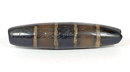 Ancient seven stripe chung dzi bead with golden-tan etched bands on near-pitch-black agate, unretouched photo by Ancient Dzi Shop