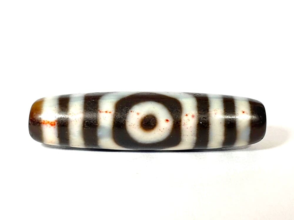 Close-up of genuine cinnabar bloodspots on an authentic antique Tibetan dzi bead — Ancient Dzi Shop