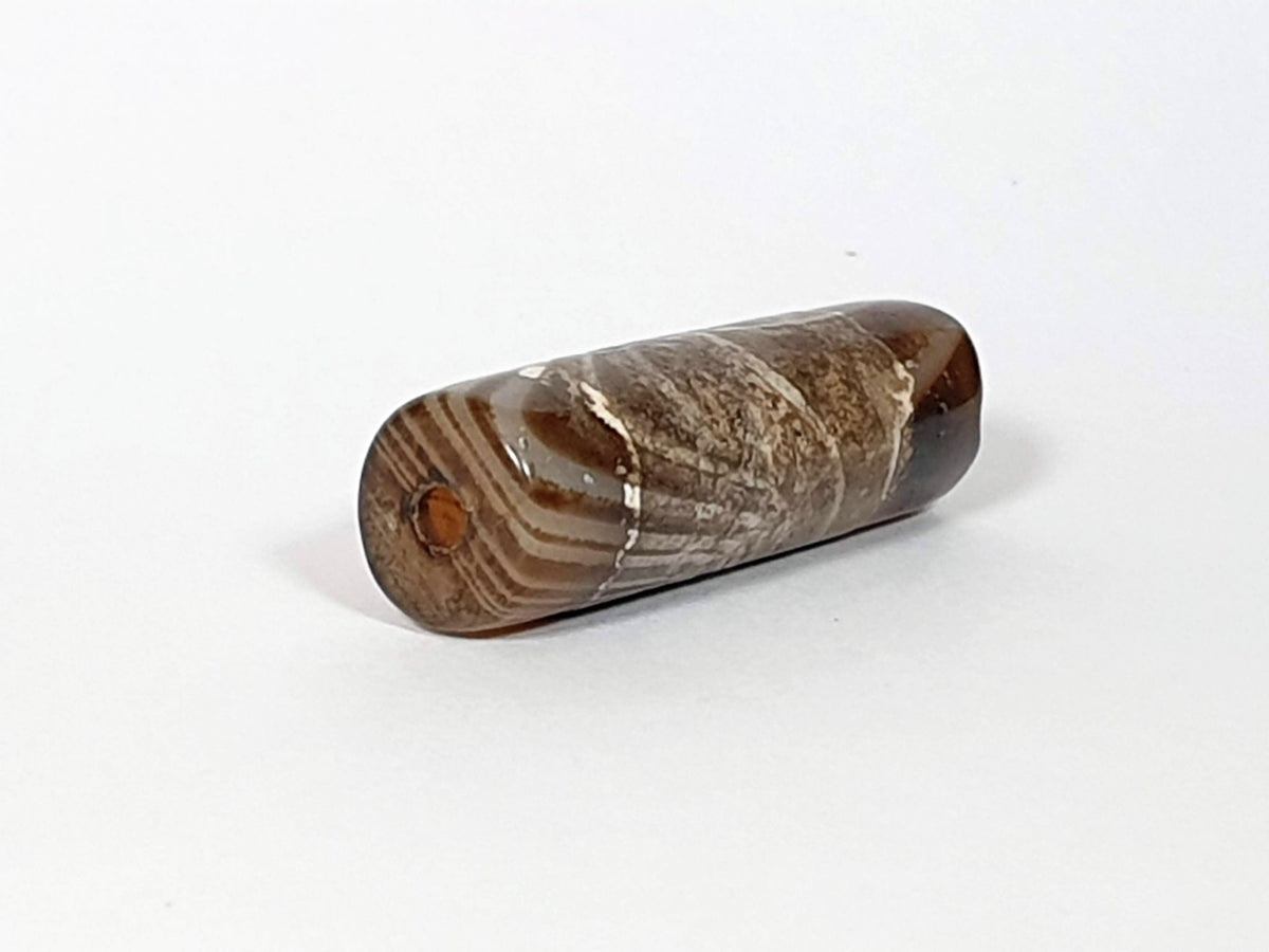 At-030420-1SNP, left end cap, off-centre drill hole, natural agate banding on end face, tobacco-brown body, unretouched