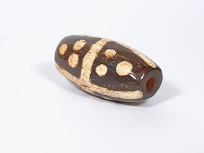Ancient eighteen star motif agate dzi beads with dark brown and cream patterning, showing natural patina and center drill holes