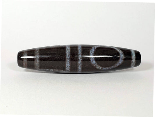 N-062126-HE dzi bead, angled view of opposite drilled end, full motif visible, unretouched
