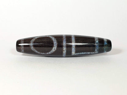 N-062126-HE dzi bead, three-quarter angle showing drilled end, unretouched