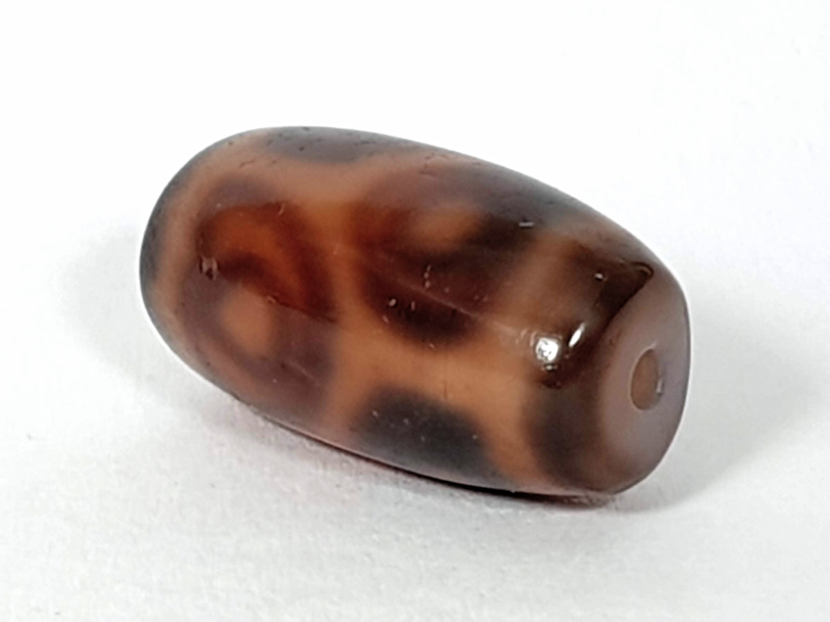Antique six-eye lotus dzi bead, brown agate with dark mottled patina, visible drill hole, aged surface texture