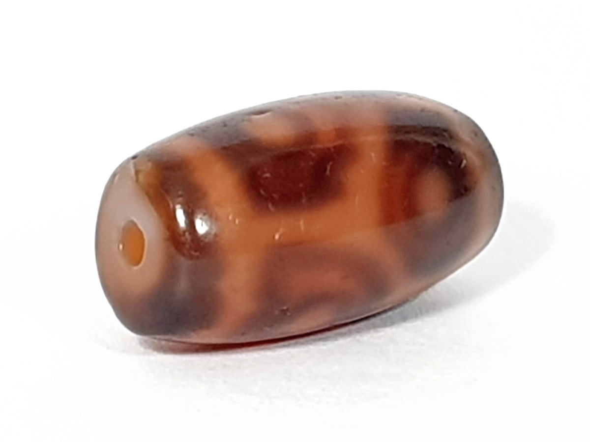 Antique six eye lotus dzi bead, brown agate, natural patina, visible drill hole, dark mottled patterning, oval barrel shape