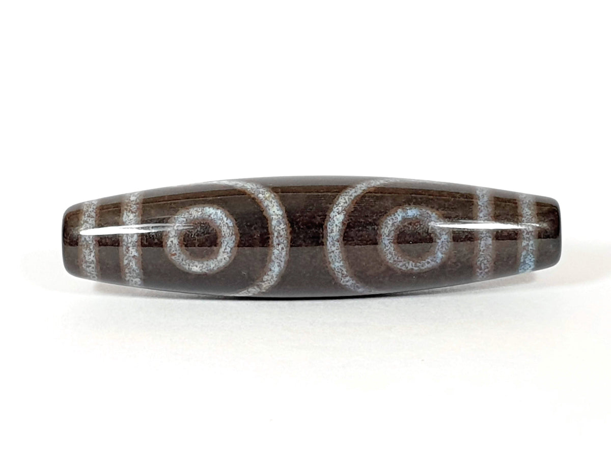 Three-eye dzi bead with bloodspots, etched agate pattern, natural striping, and central drill holes