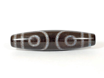 Three-eye dzi bead with bloodspots, etched agate pattern, natural striping, and central drill holes