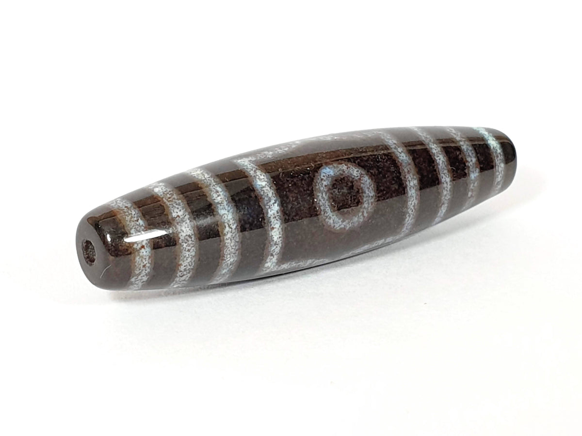 Three eye dzi bead with brown agate and white striping, bloodspot patterns, and center drill hole
