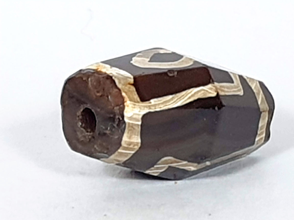 At-120120-2E7, octagonal end face with drilled hole, ancient weathering and oxidation around hole, unretouched