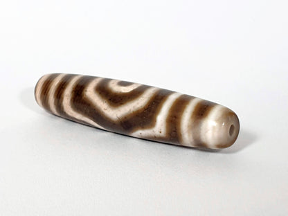 Qing Dynasty three eye dzi — angled end, drill hole at narrow tip, concentric arc stripes on cream-brown body, At-0426-3EQ