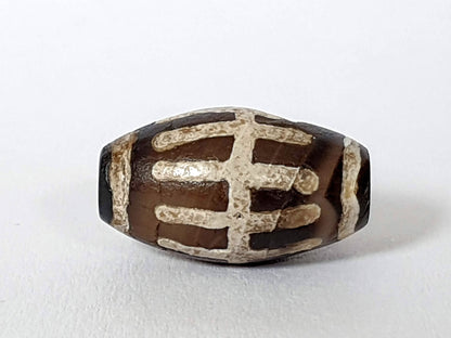 Ac-062426-SR Bead A angled view near-black end cap zone small drill hole sun ray motif unretouched