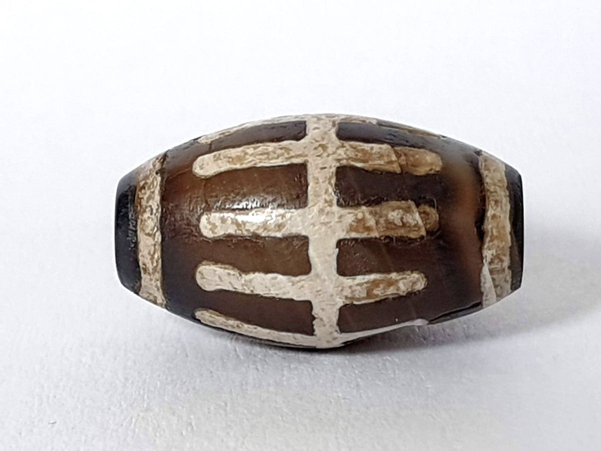Ac-062426-SR Bead B angled view deeply saturated near-black ground raised mineralised sun ray motif unretouched