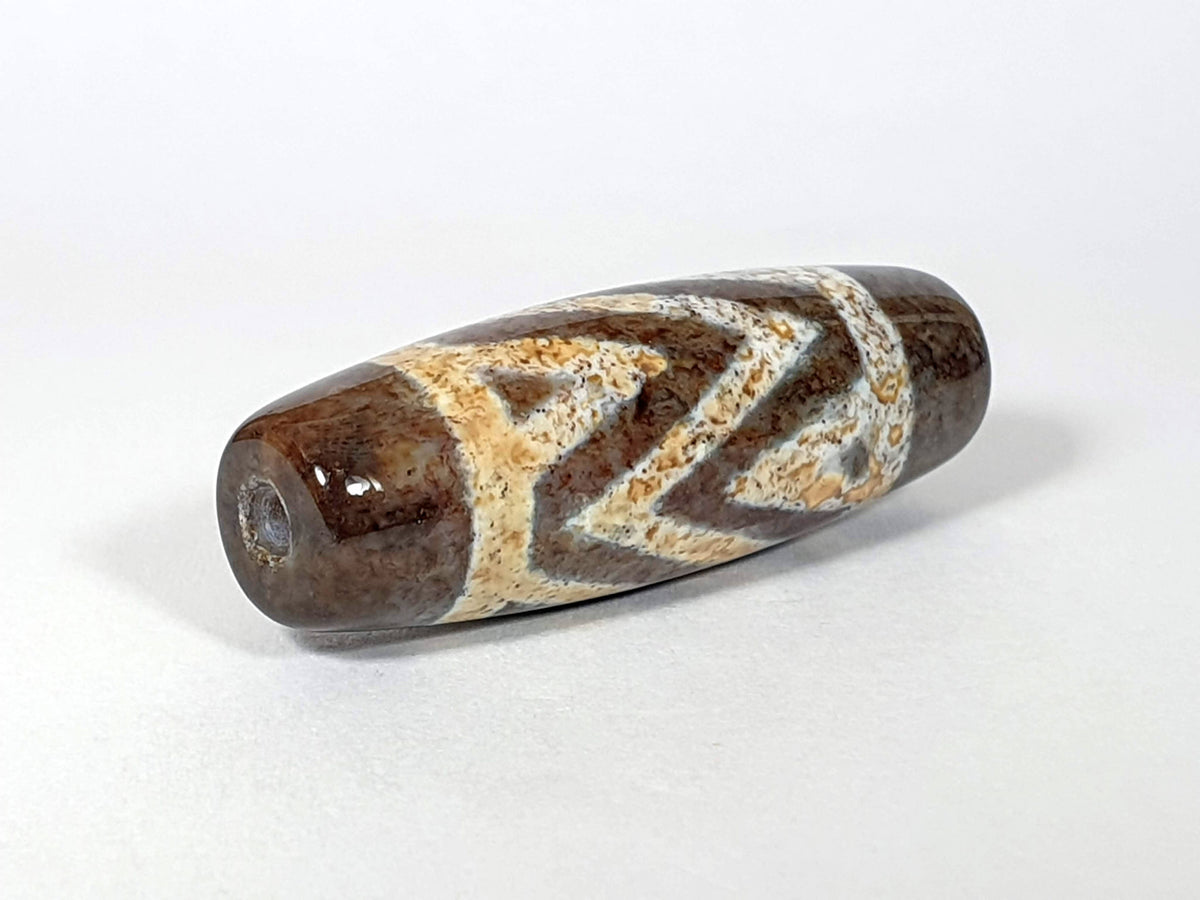 N-062426-3TSBS Bead B three stripe tiger dzi 39.6x13.8mm opposite end pale blue-grey motif drill hole unretouched