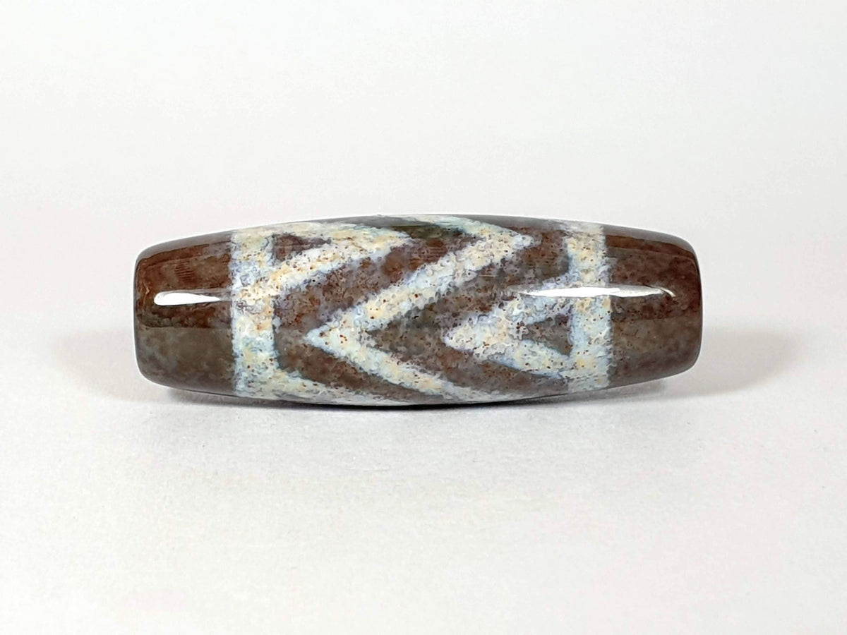 N-062426-3TSBS Bead B three stripe tiger dzi angled view cool blue-grey chevron motif dark brown ground unretouched