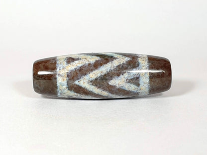 N-062426-3TSBS Bead B three stripe tiger dzi angled view cool blue-grey chevron motif dark brown ground unretouched