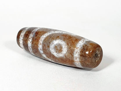 N-062126-2E2 dzi bead, straight side profile, tighter eye face visible, unretouched