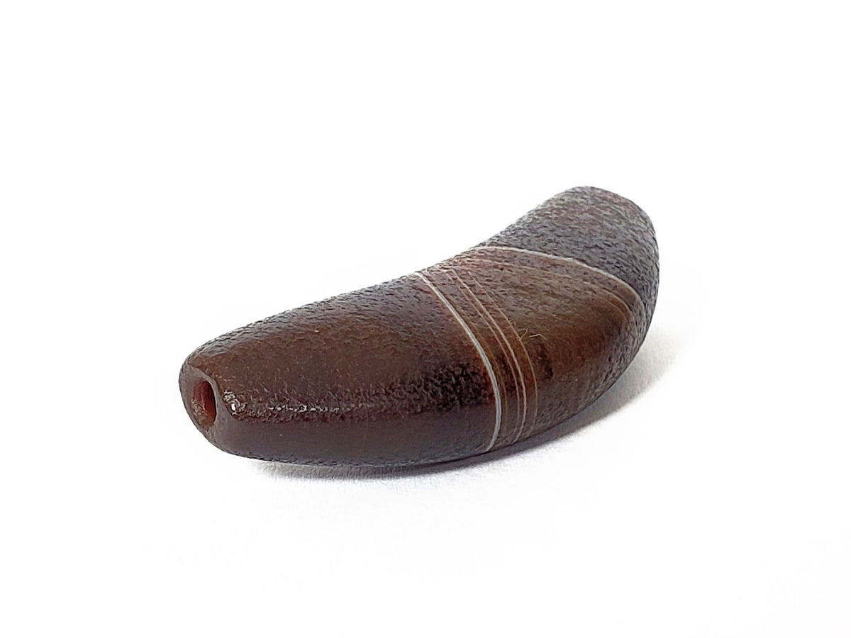 Bow shaped natural banded agate dzi bead with brown and grey striping and visible drill hole