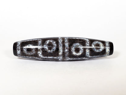 N-062126-12E-2 dzi bead, close side profile, visible surface speckling, unretouched