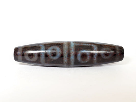 N-062126-12E-1 dzi bead, three-quarter angle showing drilled end, unretouched