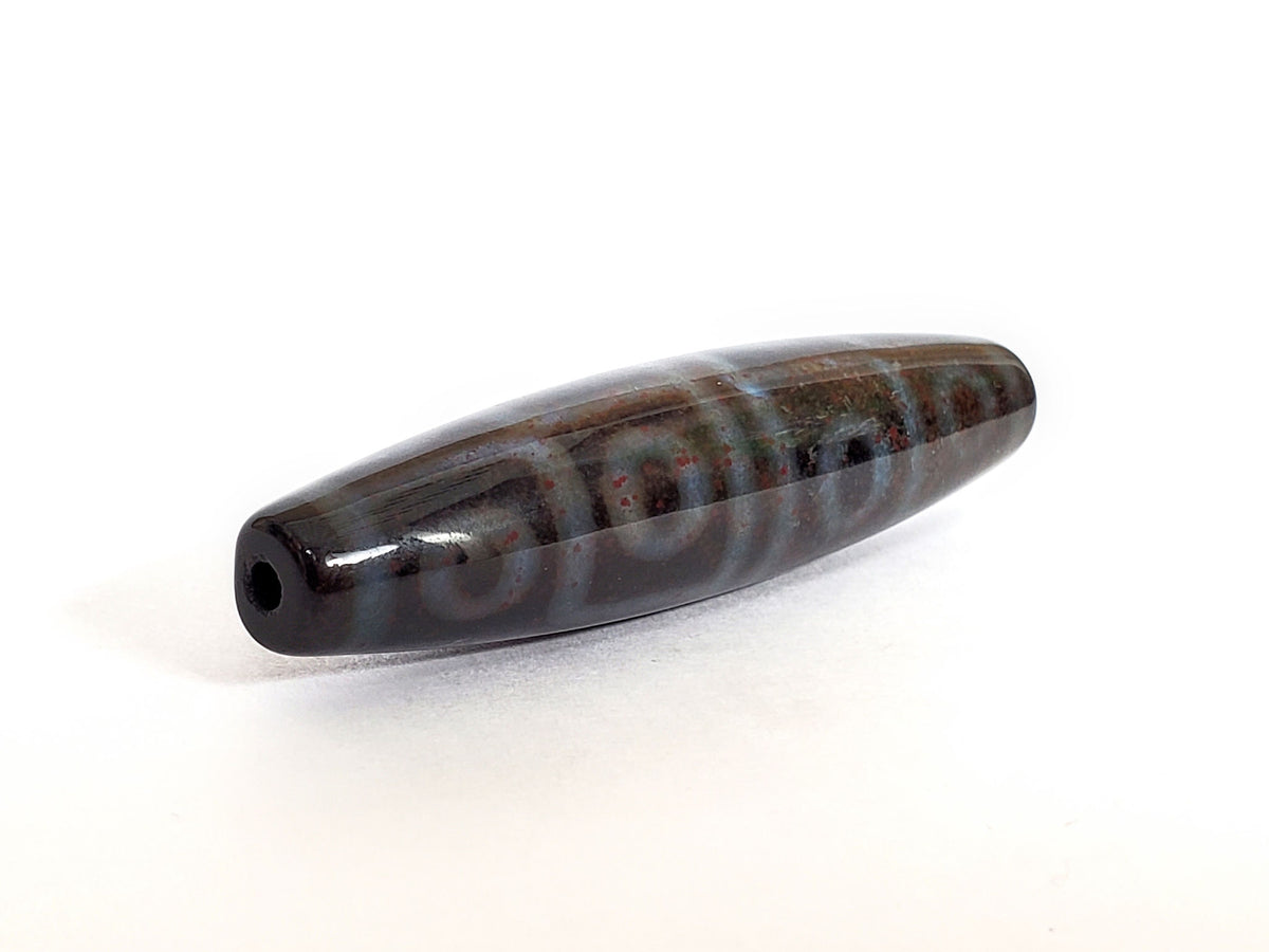Twelve eye dzi bead with bloodspots, dark agate striped pattern, polished surface, center drill hole