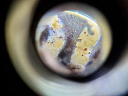 Nine-eye dzi bead with bloodspots, natural agate patterns, cream and grey tones, drilled hole visible