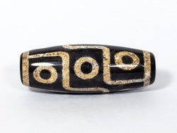 Nine-eye dzi bead with black and cream agate pattern, bloodspots, and central drill hole
