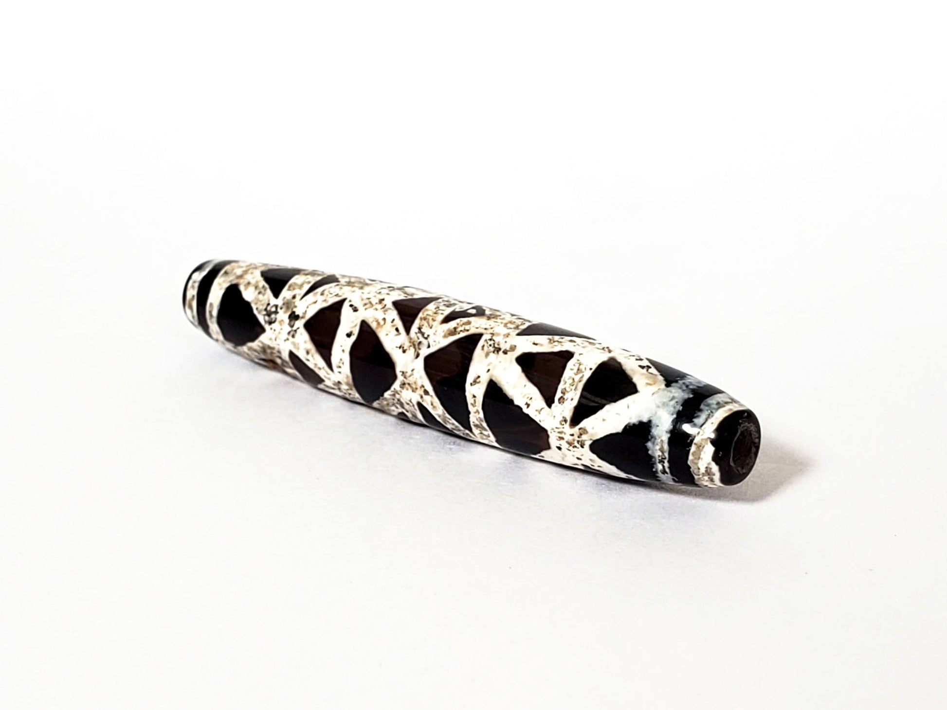 Ac-062426-CCX Bead A criss-cross carnelian dzi 49.2x9.1mm 500-700 yrs warm burgundy-brown ground drill hole unretouched