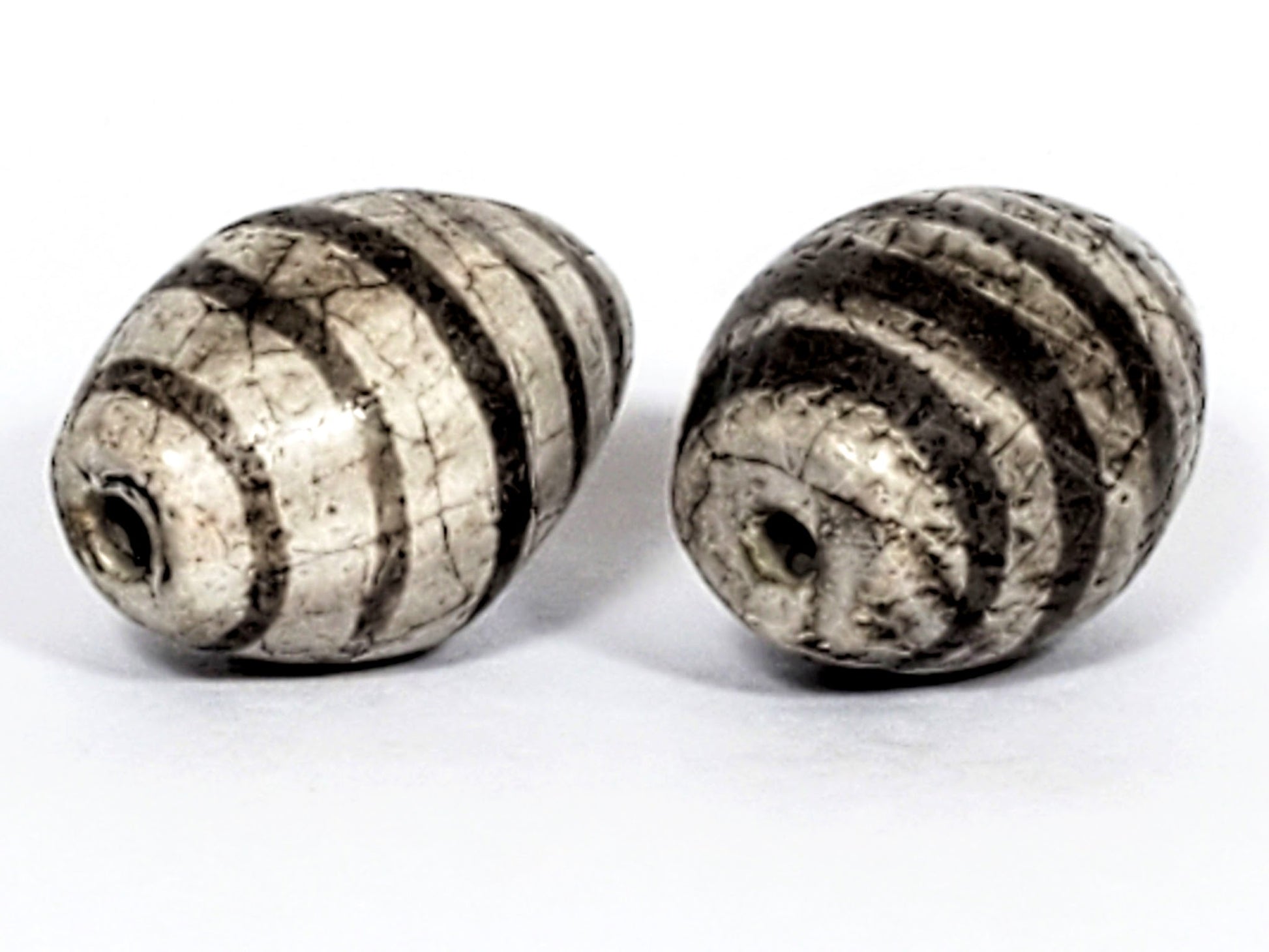Ac-062626-9SChung2 pair ancient Chung dzi, drill end view, stripe softening age detail visible, unretouched