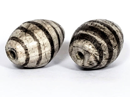 Ac-062626-9SChung2 pair ancient Chung dzi, drill end view, stripe softening age detail visible, unretouched