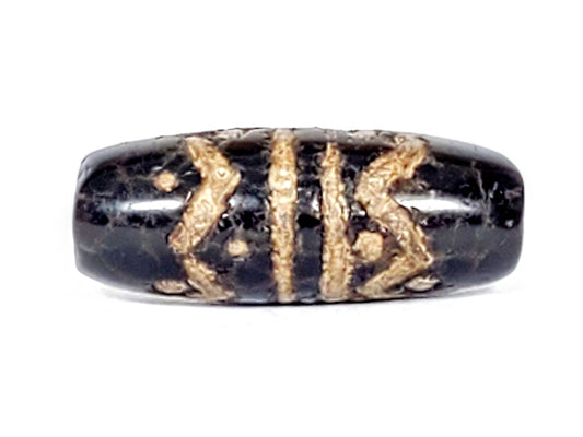 Ancient dzi bead black agate wave star motif gold patina oval barrel shape visible drill holes aged surface texture