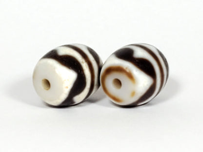 V-041122-DTT pair vintage double tiger tooth dzi, drill end view, Bead A honey-tan ring, Bead B cream-white, unretouched