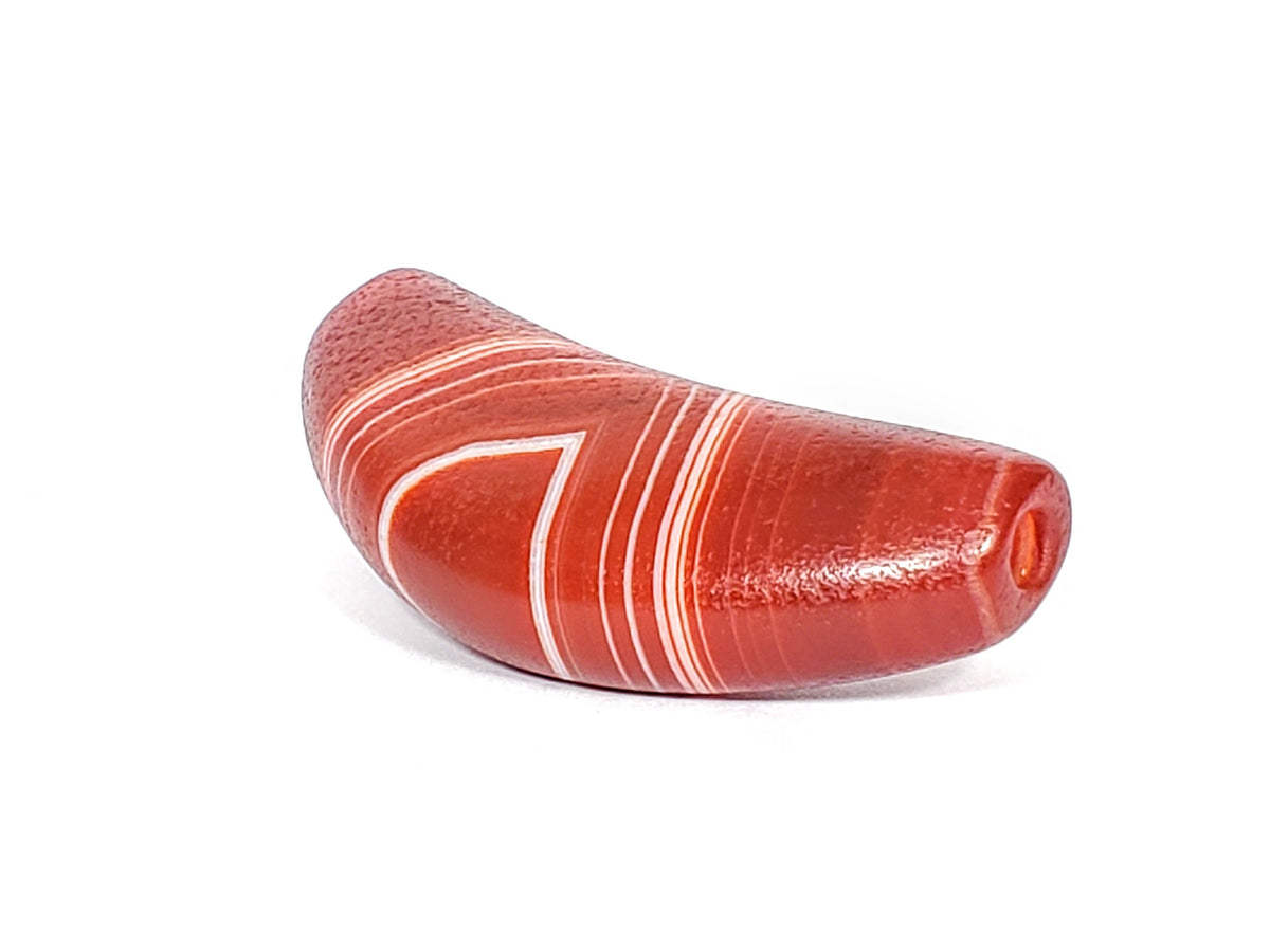 Bow shaped natural banded agate dzi bead with white striping and red-orange coloring, drilled hole visible