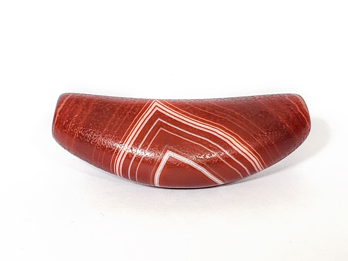Red banded agate dzi bead with white striped bow motif pattern, polished natural stone surface